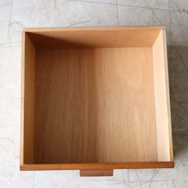 Open teak drawer with smooth wood grain and clean edges, vintage mid-century design.