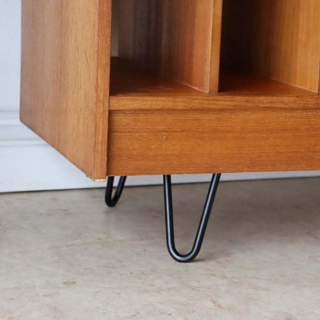 Vintage teak TV board corner with visible wood grain, clean lines, and black mid-century British hairpin iron legs.