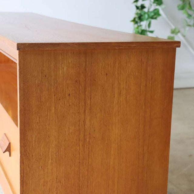 Vintage teak TV board with smooth wood grain, mid-century British style, slender iron legs, clean lines, warm natural finish.