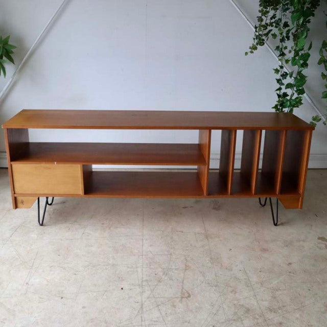 Vintage mid-century teak TV board with British-Denmark design, featuring open shelves, vertical slats, and slender iron.