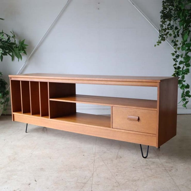 Vintage teak mid-century TV board with British-Denmark design, open shelves, drawers, and hairpin iron legs.