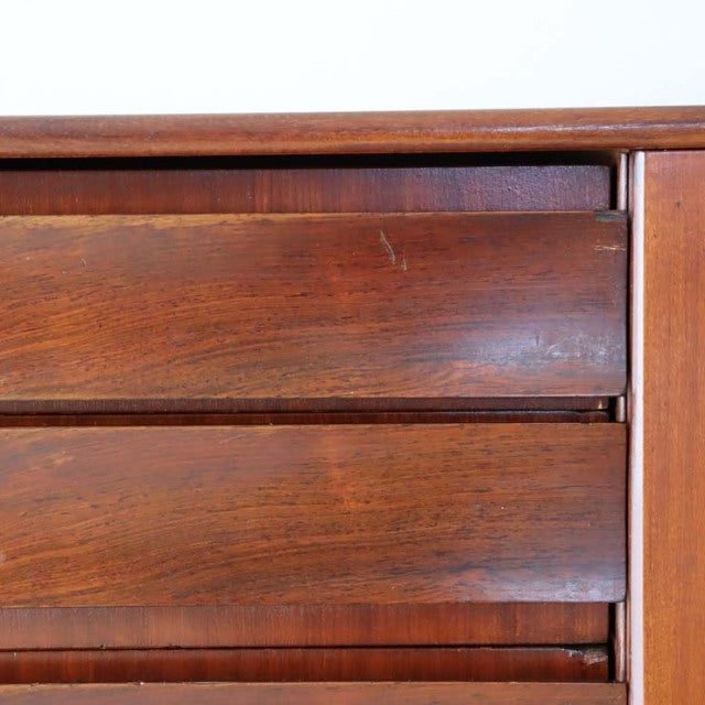 Close-up of vintage British mid-century teak wood sideboard drawer front with rich grain and smooth finish.