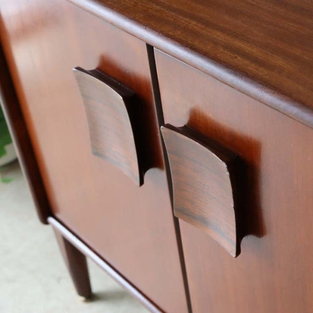 Mid-century British teak sideboard by Elliotts of Newbury with distinctive curved wooden handles and rich wood grain.