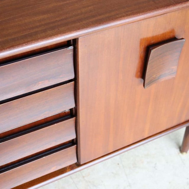 Mid-century British teak sideboard by Elliotts of Newbury with rich wood grain, four drawers, and geometric handle detail.
