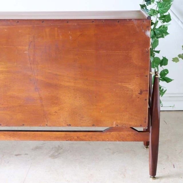 Mid-century British teak sideboard with rich wood grain, tapered legs, and sleek floating-style design.