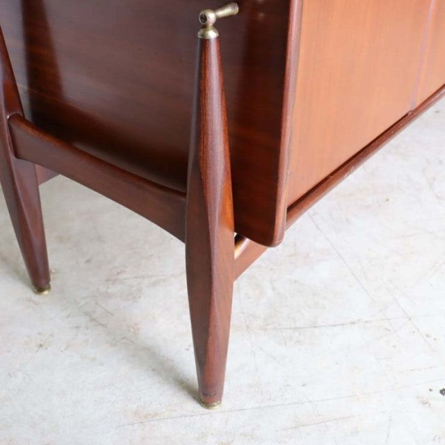 Mid-century British teak sideboard corner with rich wood grain, tapered legs, and floating style base by Elliotts of Newbury.