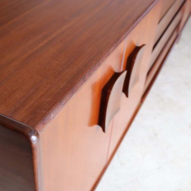 Mid-century British teak sideboard by Elliotts of Newbury with rich wood grain and sculpted handles.