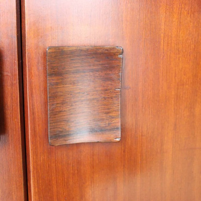 Close-up of British mid-century teak sideboard door featuring a dark Zebrano wood handle with visible grain and clean edges.