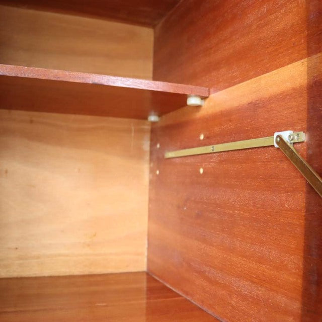 Close-up view of vintage mid-century teak wood interior with visible wood grain and brass support bracket inside British.
