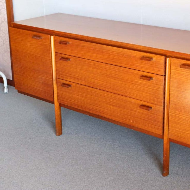 Vintage mid-century teak sideboard with rich wood grain, clean lines, and tapered legs, British-Denmark style.