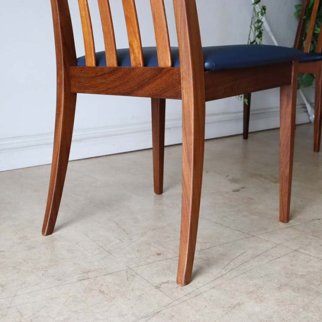 Set of four vintage mid-century British G-PLAN Fresco teak dining chairs with navy blue upholstered seats, showcasing.