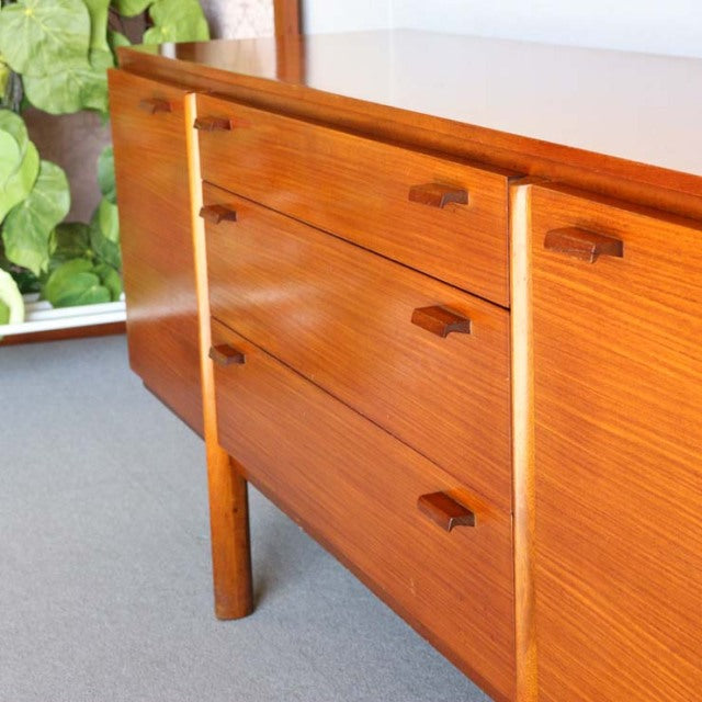 Vintage mid-century teak sideboard with sleek British design, showcasing rich wood grain and tapered legs from Denmark.