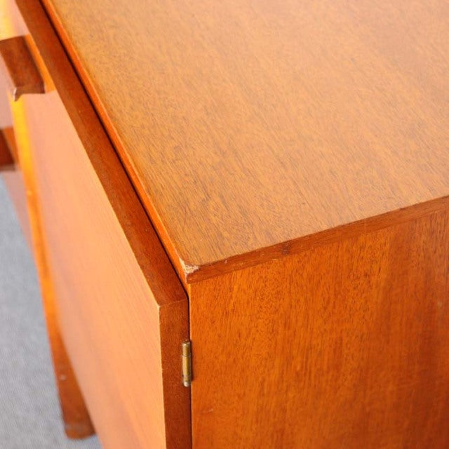Close-up of teak wood grain and corner detail on British mid-century vintage sideboard with sleek edges and hinged door.