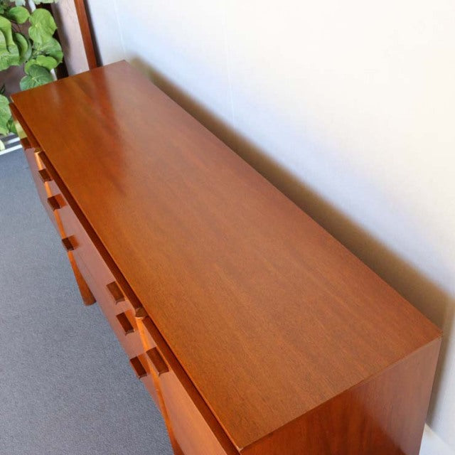 Mid-century British teak sideboard with smooth wood grain, rectangular top, and tapered legs, vintage Danish design.