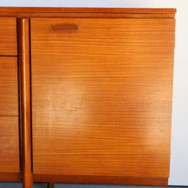 Vintage teak sideboard with smooth wood grain, mid-century British design, clean lines, and tapered legs.
