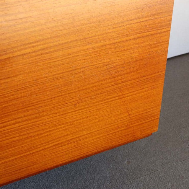 Close-up of vintage teak sideboard corner showcasing rich wood grain and smooth mid-century British craftsmanship from.
