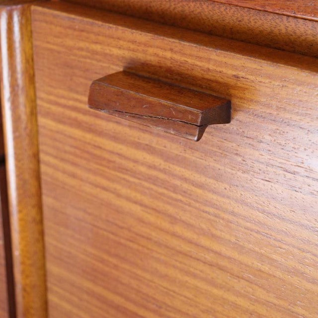 Close-up of vintage teak sideboard drawer handle with rich wood grain, showcasing mid-century British craftsmanship.