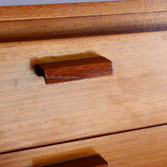 Close-up of vintage British mid-century teak sideboard drawer with rich wood grain and rectangular handle.