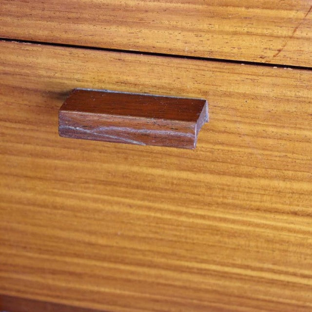 Close-up of vintage teak sideboard handle showcasing warm wood grain and smooth mid-century British craftsmanship detail.