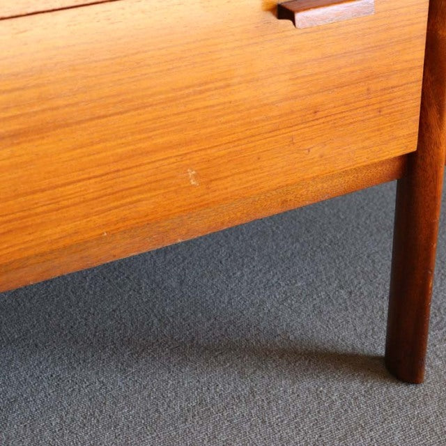 Close-up of vintage mid-century British teak sideboard leg and wood grain with warm honey tones and smooth finish.