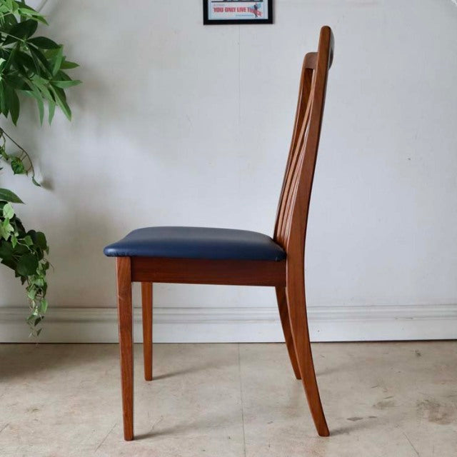 Set of four vintage mid-century G-PLAN Fresco dining chairs in teak with navy blue upholstered seats and slender tapered legs.