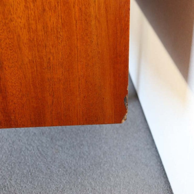 Close-up of vintage teak sideboard corner showing rich wood grain and mid-century British craftsmanship detailing.
