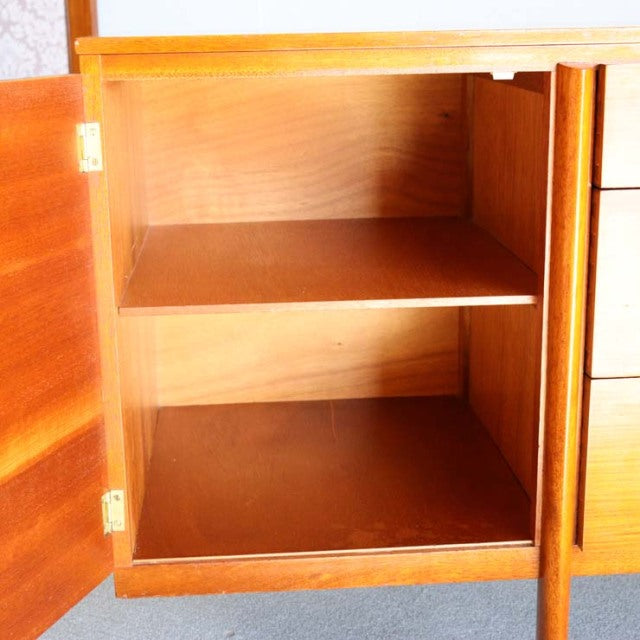 Open teak wood British mid-century vintage sideboard cabinet with visible wood grain and two shelves inside, showcasing.