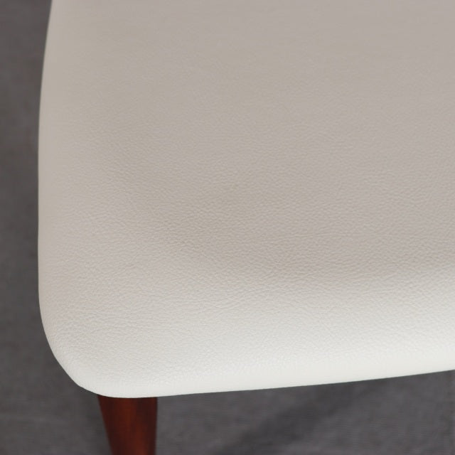 Close-up of pristine white leather seat cushion with smooth texture on vintage teak mid-century G-PLAN dining chair.