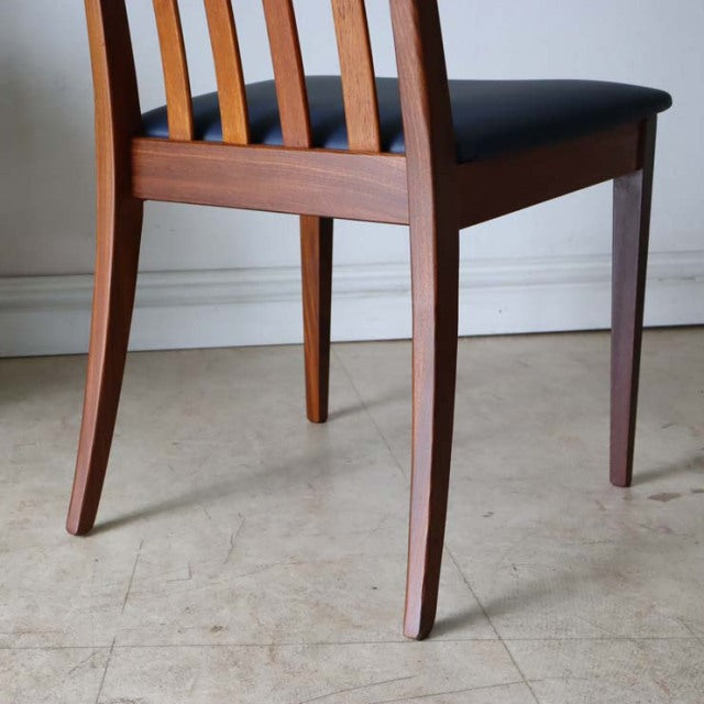 Set of four vintage G-PLAN Fresco mid-century teak dining chairs with dark blue upholstered seats and tapered legs.