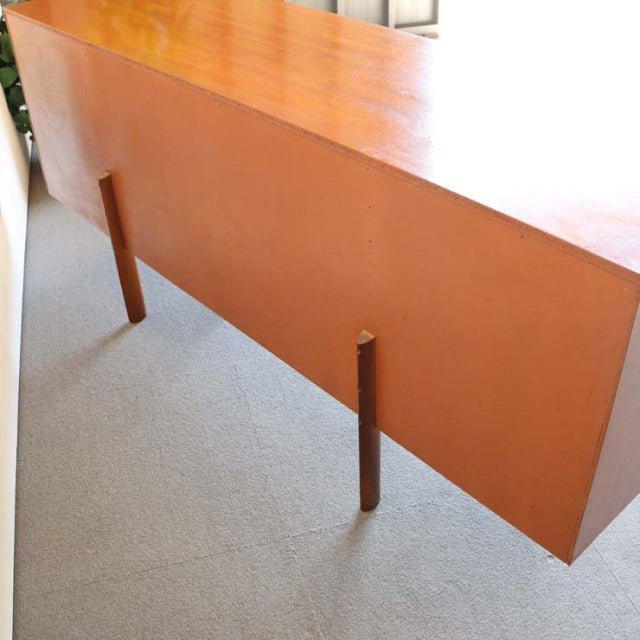 Mid-century vintage British teak sideboard with sleek wood grain, elevated by slender tapered legs, showcasing minimalist.
