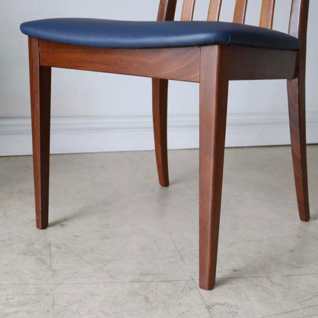 Set of four vintage mid-century G-Plan Fresco dining chairs in teak with dark navy leather seats, sleek tapered legs, and.