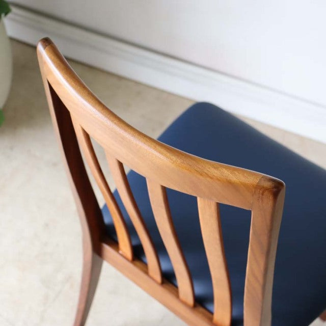 Mid-century British G-PLAN Fresco dining chair in teak with dark blue cushioned seat and curved slatted backrest.