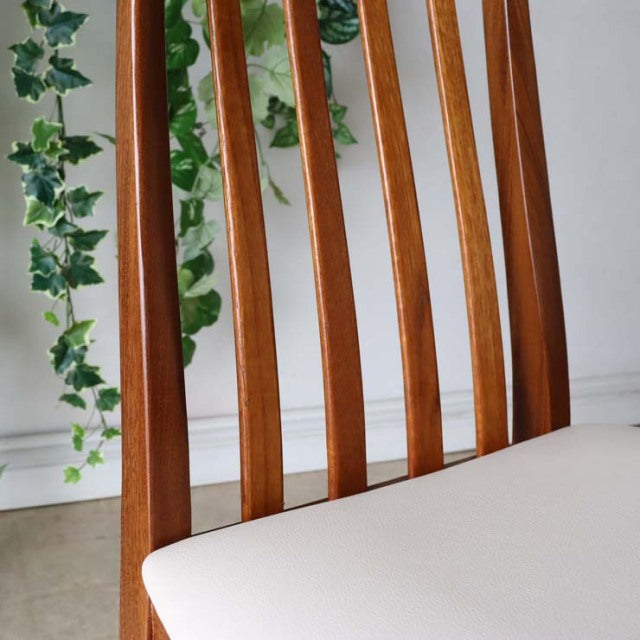 Mid-century British vintage teak dining chair with vertical slat back and ivory upholstered seat.
