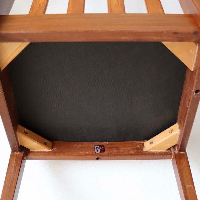 Underside view of vintage teak wood dining chair from British mid-century G-PLAN Fresco series with ivory seat upholstery.