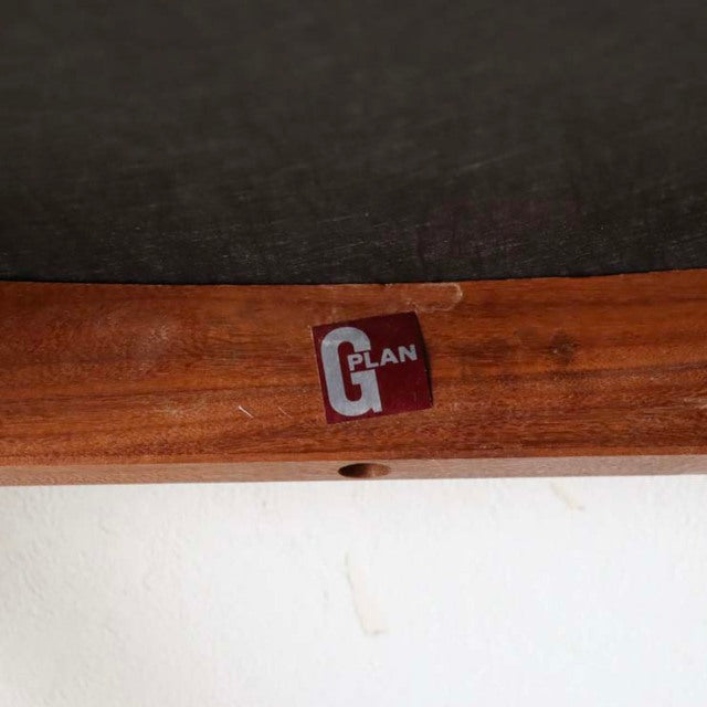 Close-up of vintage British G-Plan teak wood chair frame with rich wood grain and red G-Plan logo label.