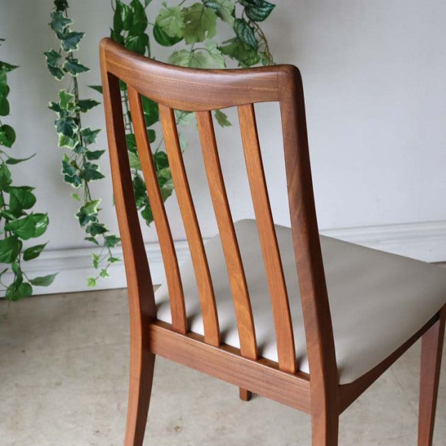 Mid-century British G-PLAN teak dining chair with ivory reupholstered seat, vertical slat backrest, and tapered legs.
