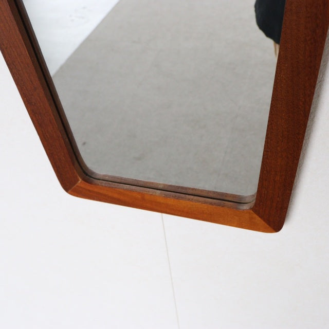 Mid-century British vintage teak wall mirror with trapezoid frame and rich wood grain detail.