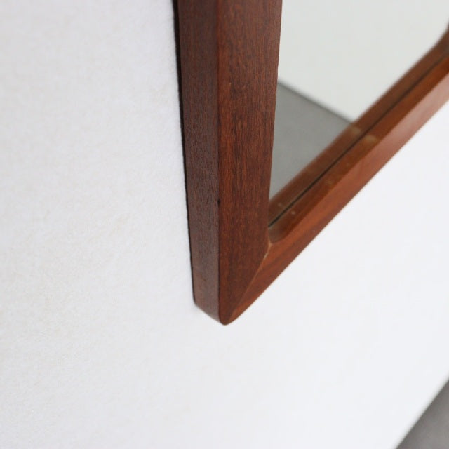 Mid-century British vintage teak trapezoid wall mirror with rich wood grain and smooth angled frame edges.