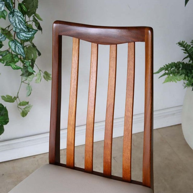 Mid-century British vintage teak dining chair with vertical slatted backrest and smooth curved top rail.