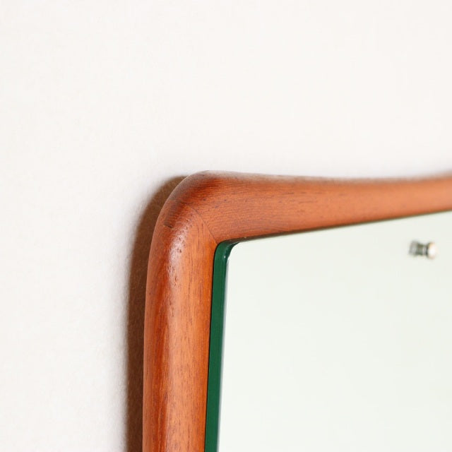 Mid-century British vintage teak wall mirror with gently curved frame and smooth wood grain detailing.