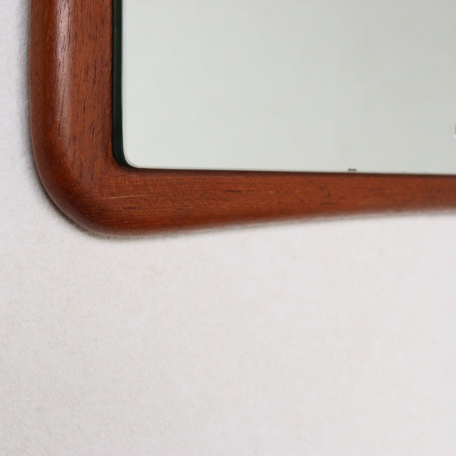 Vintage British mid-century teak wall mirror with gently curved rectangular frame and smooth wood grain finish.