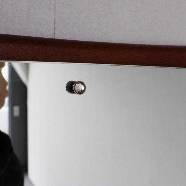 Mid-century British vintage teak wall mirror with gentle curve and polished wood grain frame.