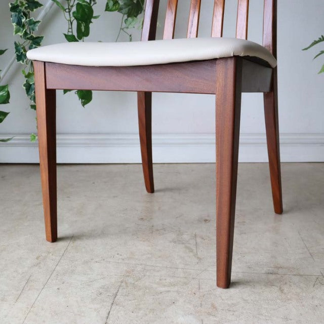 Set of four vintage mid-century British G-Plan dining chairs with teak frames, ivory upholstered seats, tapered legs, and.