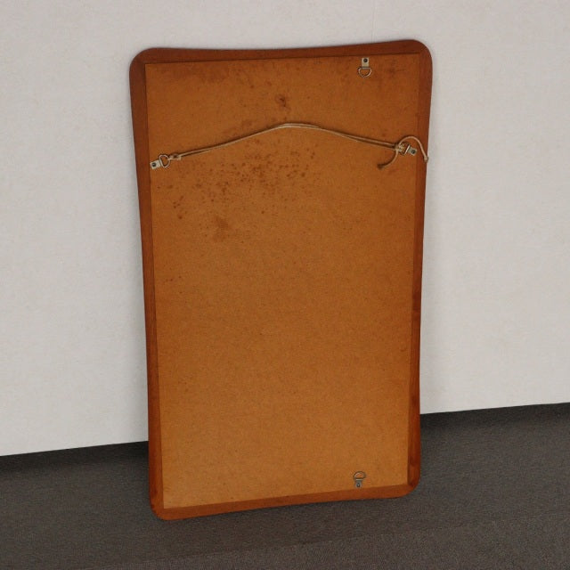 Vintage teak mid-century British wall mirror with rounded corners and natural wood grain visible on back panel.