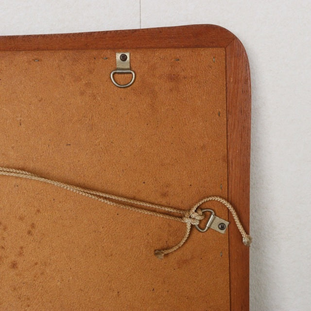 Vintage teak mid-century British wall mirror back with curved edges, hanging cord, and wood grain details.