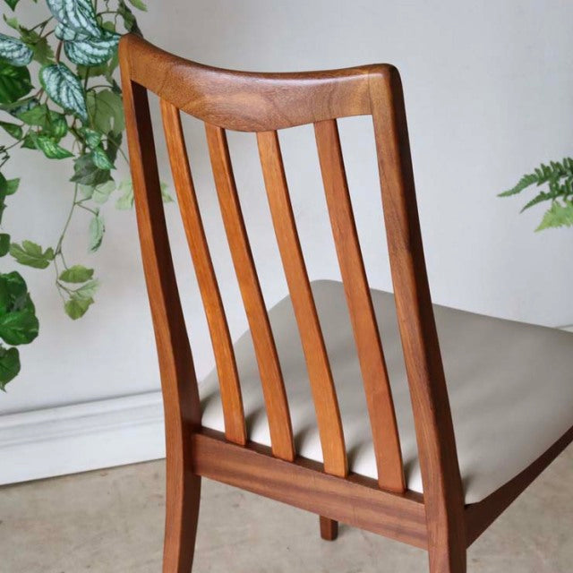 Mid-century British G-Plan teak dining chair with curved slatted back and ivory upholstered seat.
