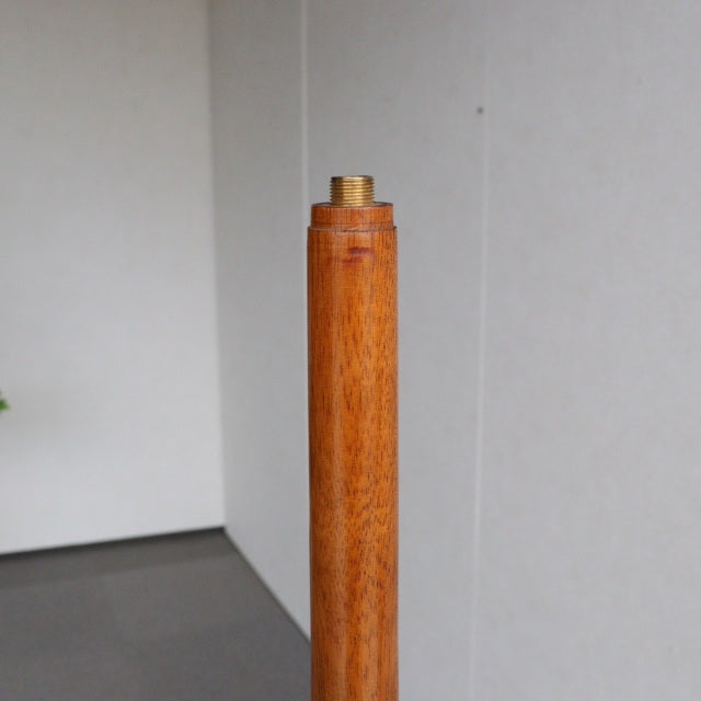 Vintage teak floor lamp base with rich wood grain, British mid-century design, slender cylindrical form.