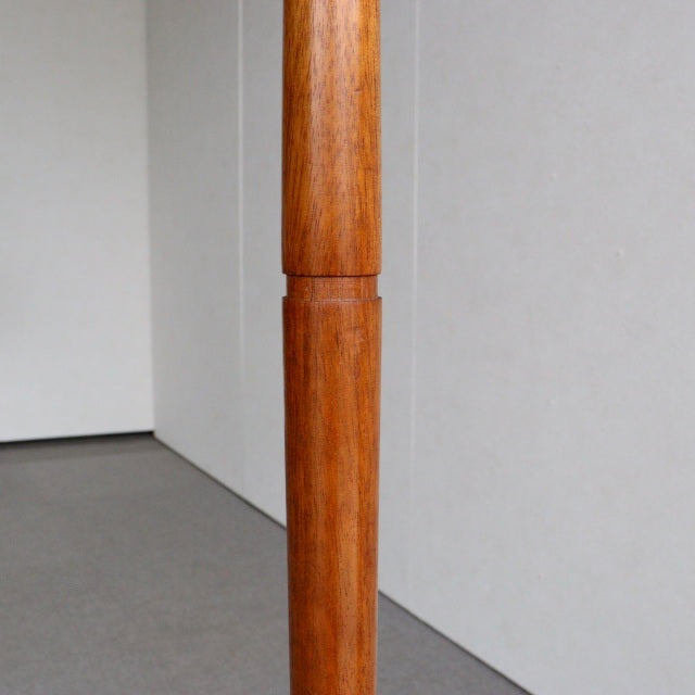 Vintage British mid-century teak floor lamp base with smooth cylindrical wood grain and streamlined form.
