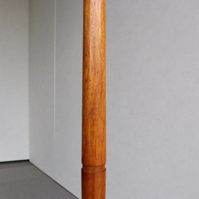 Mid-century vintage teak floor lamp leg with smooth grain, British design, warm wood tone, simple cylindrical form.