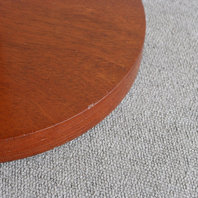 Close-up of vintage British mid-century teak floor lamp base showing rich wood grain and smooth rounded edge on light.